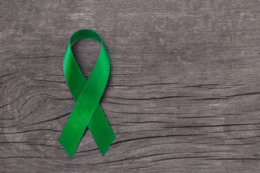 Image of a green ribbon on a wooden background